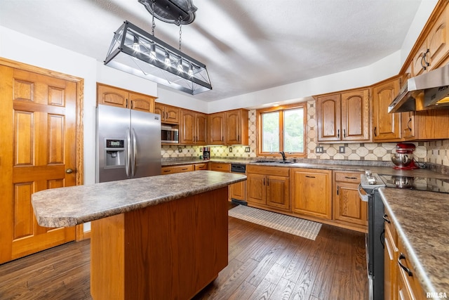 3939 Musholt Strasse Ln, Quincy, IL 62305 - kitchen featuring appliances with stainless steel finishes, exhaust hood, tasteful backsplash, brown cabinetry, and dark wood-style flooring
