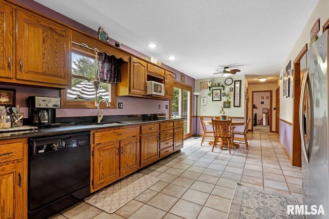 3713 Tyler Ct, Springfield, IL 62711 - kitchen featuring dishwasher, freestanding refrigerator, brown cabinetry, dark countertops, and light tile patterned floors