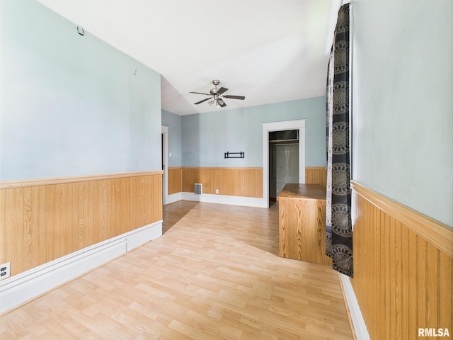 222 N Lewis St, Blue Mound, IL 62513 - spare room featuring a ceiling fan, wood finished floors, a wainscoted wall, and wooden walls