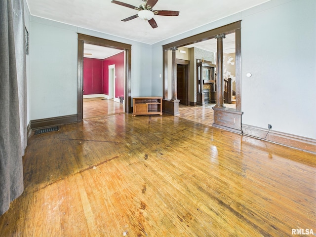 222 N Lewis St, Blue Mound, IL 62513 - empty room featuring decorative columns, a ceiling fan, and wood-type flooring
