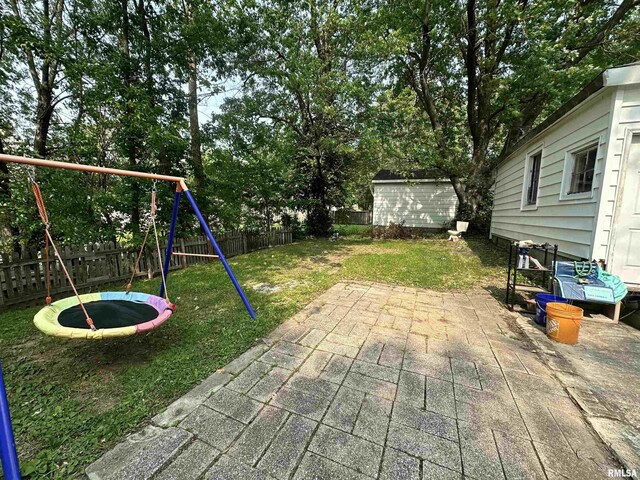 1025 S 15th St, Quincy, IL 62301 - view of jungle gym featuring a patio, a trampoline, a fenced backyard, and view of scattered trees