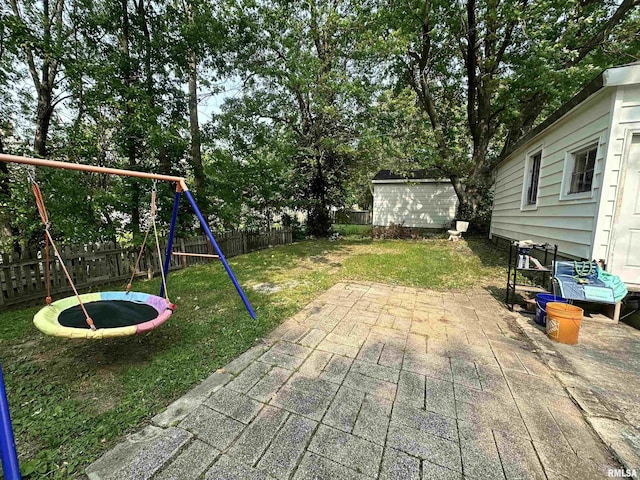 1025 S 15th St, Quincy, IL 62301 - fenced backyard with a trampoline, a patio area, a playground, and view of scattered trees