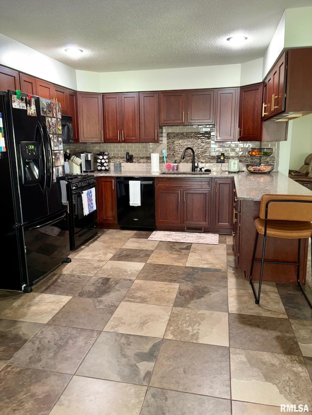 27 Apache Dr, Springfield, IL 62711 - kitchen featuring black appliances, tasteful backsplash, a textured ceiling, light stone counters, and a peninsula