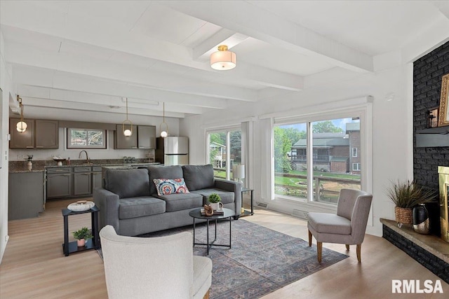 308 Elm Ln, Petersburg, IL 62675 - living room featuring light wood-style floors, beam ceiling, and a fireplace