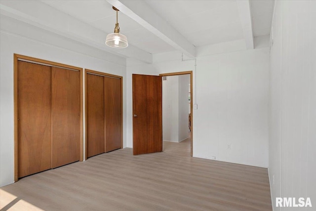 308 Elm Ln, Petersburg, IL 62675 - unfurnished bedroom with beam ceiling, two closets, and light wood-style flooring