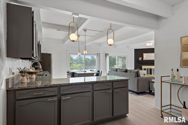 308 Elm Ln, Petersburg, IL 62675 - kitchen with light wood finished floors, dark stone countertops, gray cabinetry, beamed ceiling, and hanging light fixtures