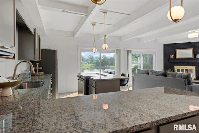 308 Elm Ln, Petersburg, IL 62675 - kitchen with stone countertops, beam ceiling, range with electric stovetop, a brick fireplace, and pendant lighting