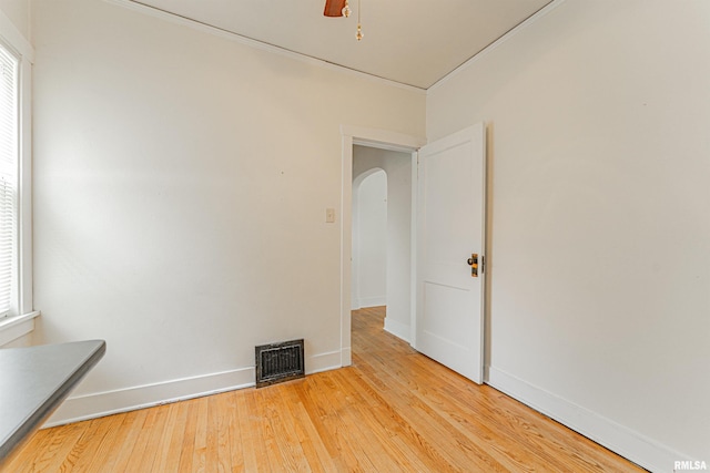 712 N Kickapoo St, Lincoln, IL 62656 - empty room featuring arched walkways, light wood-style floors, and ornamental molding