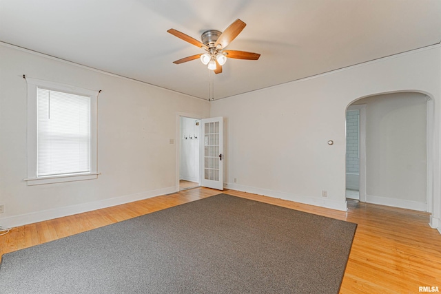 712 N Kickapoo St, Lincoln, IL 62656 - unfurnished room featuring arched walkways, a ceiling fan, and light wood-style flooring