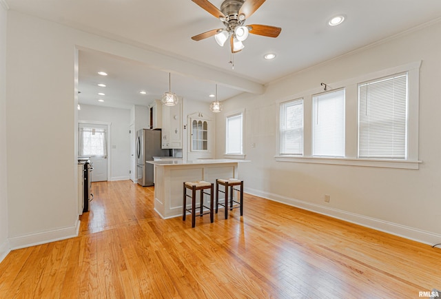 712 N Kickapoo St, Lincoln, IL 62656 - kitchen with a breakfast bar, light wood-style floors, ceiling fan, white cabinetry, and recessed lighting
