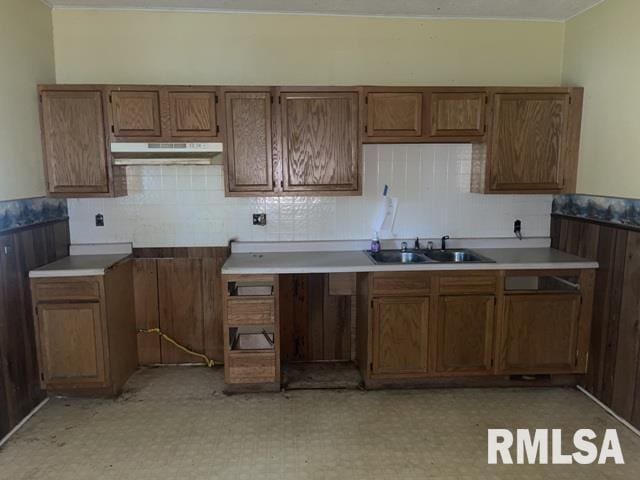 2541 S 10th St, Springfield, IL 62703 - kitchen featuring under cabinet range hood, light floors, tasteful backsplash, and brown cabinets