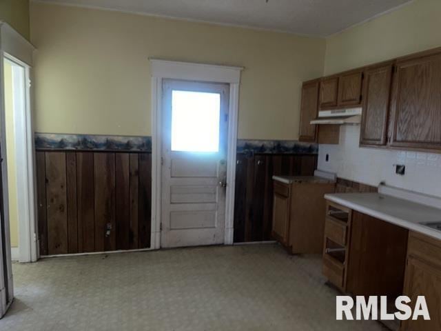 2541 S 10th St, Springfield, IL 62703 - kitchen with a wainscoted wall, under cabinet range hood, brown cabinets, and light floors