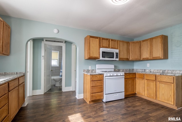 100 N Austin Ave, Abingdon, IL 61410 - kitchen featuring white appliances, arched walkways, dark wood-type flooring, and brown cabinetry