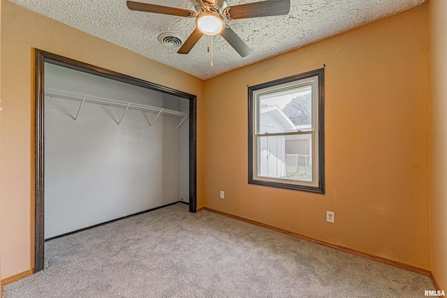 205 E Pine St, Broadwell, IL 62634 - unfurnished bedroom featuring light carpet, a textured ceiling, a closet, and a ceiling fan