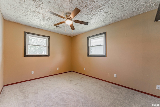 205 E Pine St, Broadwell, IL 62634 - empty room with healthy amount of natural light, a ceiling fan, carpet flooring, and a textured ceiling