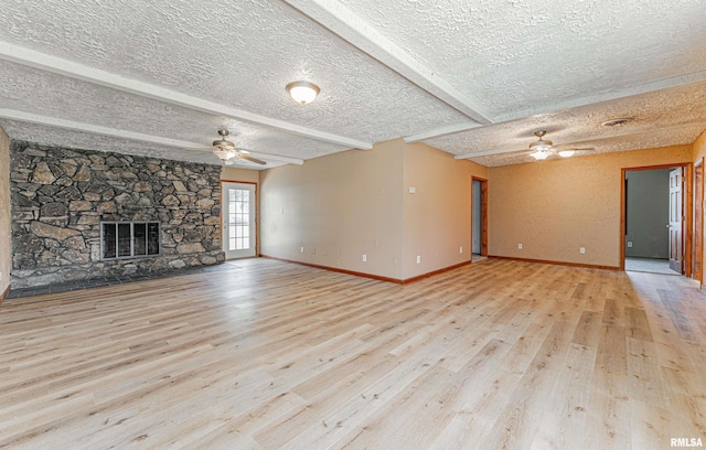 205 E Pine St, Broadwell, IL 62634 - unfurnished living room featuring ceiling fan, wood finished floors, a textured ceiling, and a stone fireplace