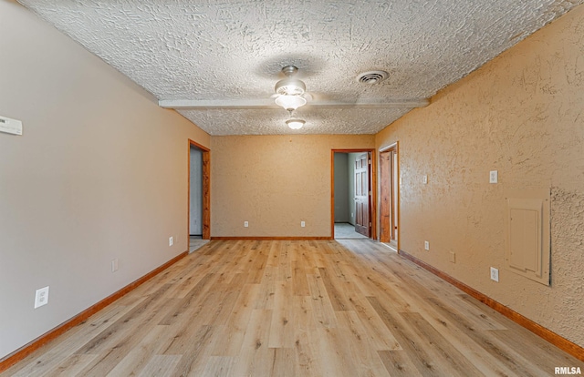 205 E Pine St, Broadwell, IL 62634 - empty room with light wood-type flooring, a textured wall, and a textured ceiling