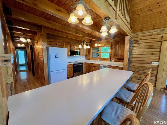 13570 Chambers Rd, Petersburg, IL 62675 - kitchen with appliances with stainless steel finishes, wooden walls, a chandelier, wood finished floors, and healthy amount of natural light
