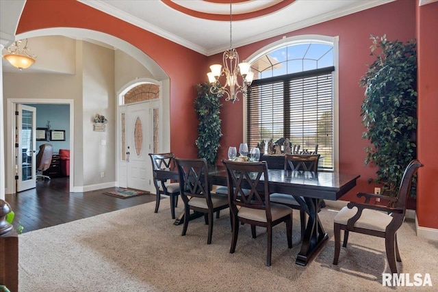 5408 Cromwell Pl, Springfield, IL 62711 - dining space with ornamental molding, arched walkways, a chandelier, wood finished floors, and a towering ceiling