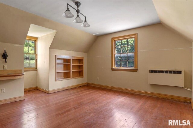 421 W Jackson Pkwy, Springfield, IL 62704 - additional living space with radiator heating unit, vaulted ceiling, built in features, and hardwood / wood-style floors