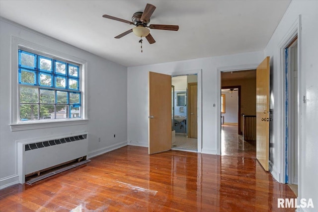 421 W Jackson Pkwy, Springfield, IL 62704 - unfurnished bedroom with radiator, wood finished floors, and a ceiling fan