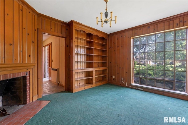 421 W Jackson Pkwy, Springfield, IL 62704 - carpeted empty room featuring a chandelier, wooden walls, plenty of natural light, a brick fireplace, and ornamental molding