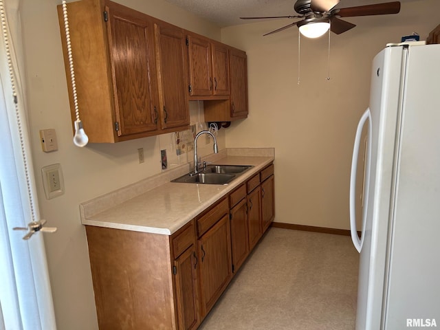 100 E Heights Ave, Taylorville, IL 62568 - kitchen with freestanding refrigerator, ceiling fan, light countertops, and brown cabinetry