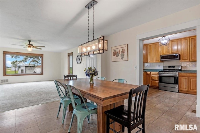 240 Mine Ave, Girard, IL 62640 - dining area with light colored carpet, light tile patterned floors, a chandelier, and ceiling fan