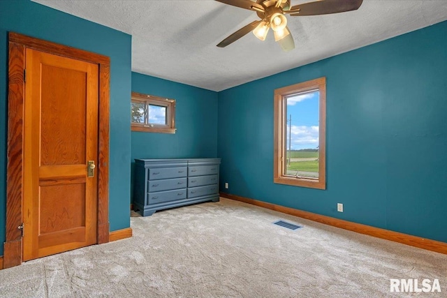 240 Mine Ave, Girard, IL 62640 - unfurnished bedroom with carpet, a textured ceiling, and a ceiling fan
