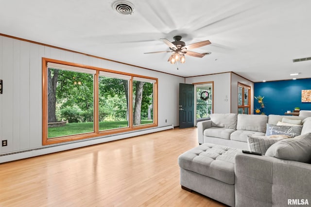 1847 New Salem Church Rd, New Berlin, IL 62670 - living area with a baseboard heating unit, healthy amount of natural light, wood finished floors, a ceiling fan, and ornamental molding