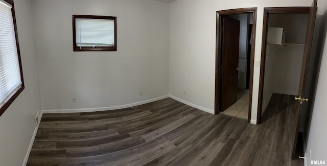 516 E Ash St, Springfield, IL 62703 - unfurnished bedroom featuring dark wood-style floors, a closet, multiple windows, and a spacious closet
