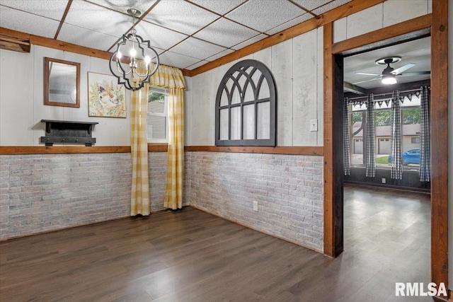 209 W Madison St, Athens, IL 62613 - unfurnished dining area with brick wall, wood finished floors, a chandelier, and a ceiling fan