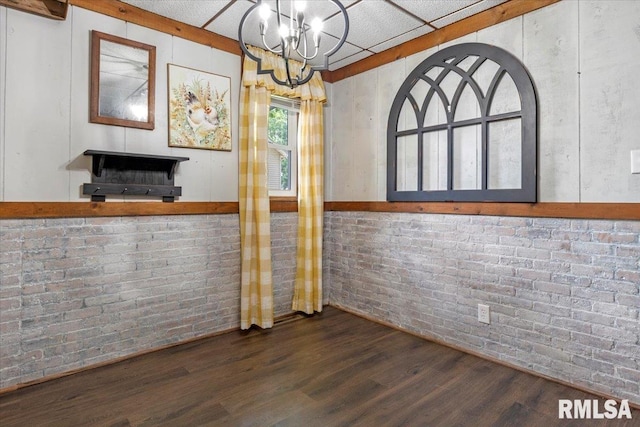 209 W Madison St, Athens, IL 62613 - unfurnished dining area with wood finished floors, a chandelier, and brick wall