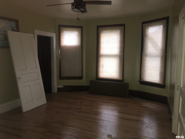 342 W Reynolds St, Springfield, IL 62702 - empty room featuring radiator heating unit, a ceiling fan, and wood finished floors