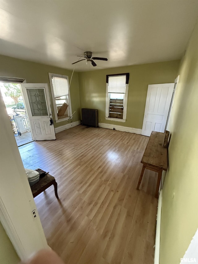 342 W Reynolds St, Springfield, IL 62702 - unfurnished living room with radiator, light wood finished floors, and ceiling fan