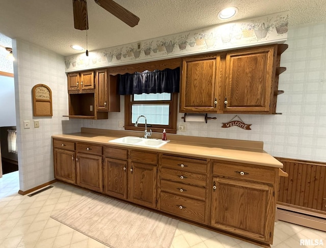 597 Walnut St, Knoxville, IL 61448 - kitchen with wallpapered walls, a textured ceiling, open shelves, brown cabinetry, and a ceiling fan