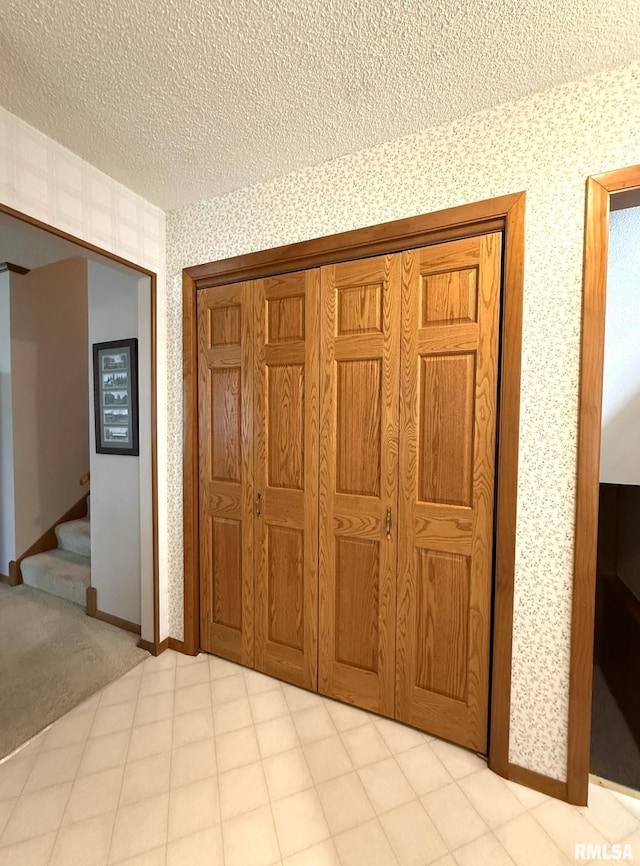 597 Walnut St, Knoxville, IL 61448 - unfurnished bedroom with wallpapered walls, a textured ceiling, and a closet