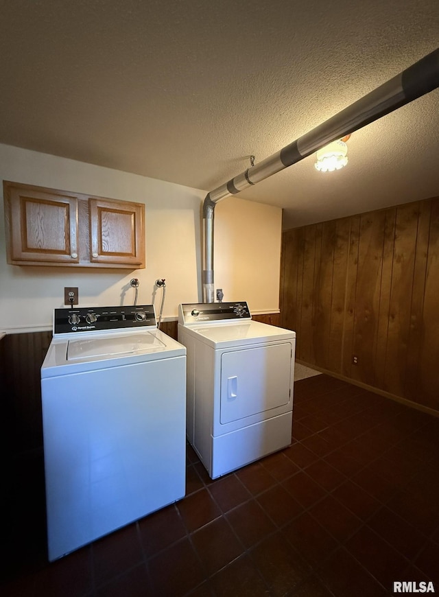 597 Walnut St, Knoxville, IL 61448 - laundry area featuring washer and clothes dryer, wood walls, dark tile patterned floors, and a textured ceiling
