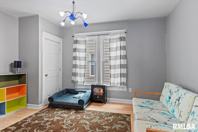 826 S Douglas Ave, Springfield, IL 62704 - sitting room with a wood stove, wood finished floors, and a chandelier