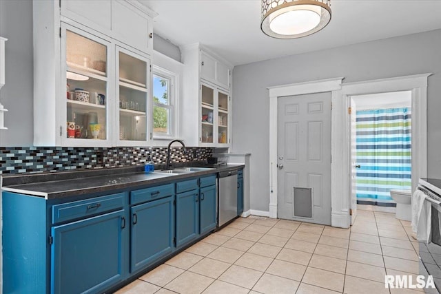 826 S Douglas Ave, Springfield, IL 62704 - kitchen featuring stainless steel dishwasher, blue cabinets, backsplash, dark countertops, and light tile patterned floors