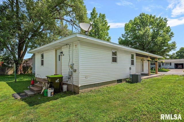 707 N Adams St, Lincoln, IL 62656 - view of side of home featuring a lawn and a central AC unit