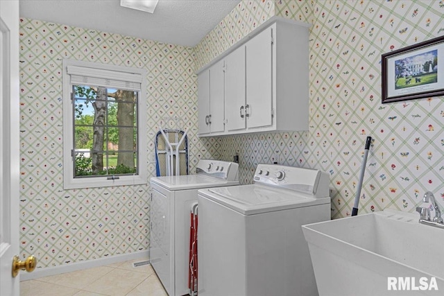 828 Coventry Pt, Springfield, IL 62702 - laundry room with washing machine and dryer, cabinet space, wallpapered walls, light tile patterned floors, and a textured ceiling