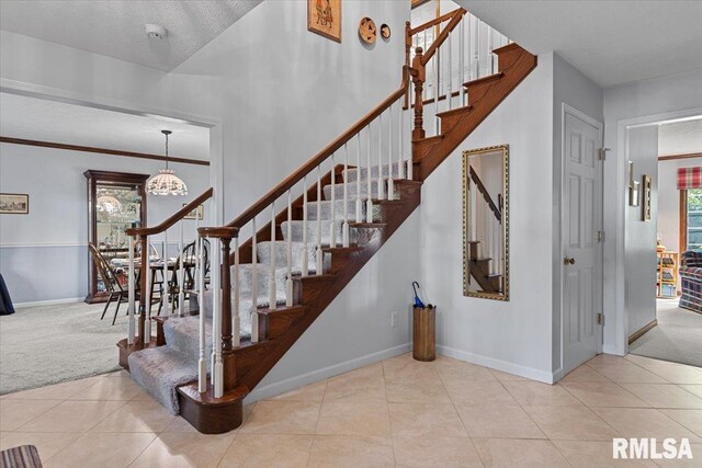 828 Coventry Pt, Springfield, IL 62702 - staircase with a chandelier, tile patterned floors, and carpet