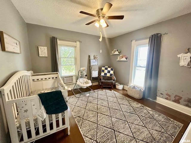 120 S Walnut St, Assumption, IL 62510 - bedroom with dark wood-style flooring, multiple windows, a textured ceiling, ceiling fan, and cooling unit