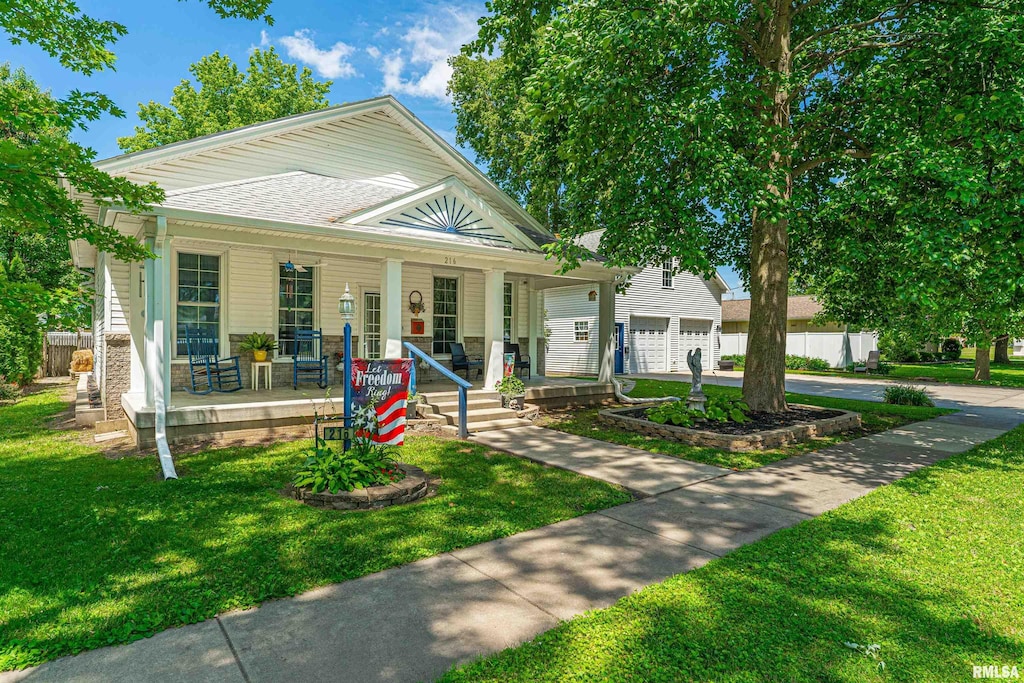 216 3rd St, Lincoln, IL 62656 - view of front of property with covered porch, a garage, and driveway