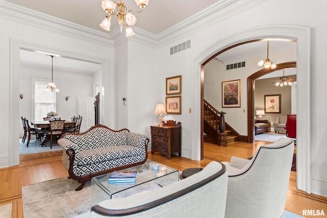 1125 Williams Blvd, Springfield, IL 62704 - living room with a chandelier, arched walkways, stairway, crown molding, and light wood-type flooring