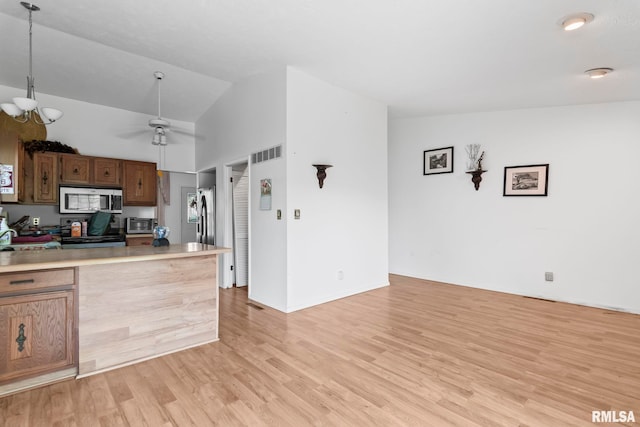 2924 Flowerbrook Ct, Springfield, IL 62702 - kitchen with stainless steel microwave, lofted ceiling, light wood-style flooring, stove, and light countertops