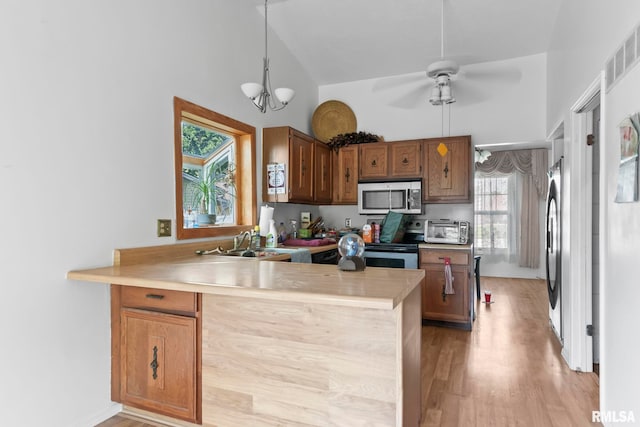 2924 Flowerbrook Ct, Springfield, IL 62702 - kitchen featuring stainless steel microwave, a peninsula, light countertops, light wood finished floors, and high vaulted ceiling
