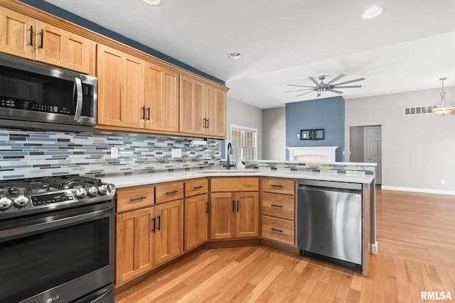 401 Cherry Cir, Williamsville, IL 62693 - kitchen with appliances with stainless steel finishes, a peninsula, a ceiling fan, light countertops, and tasteful backsplash