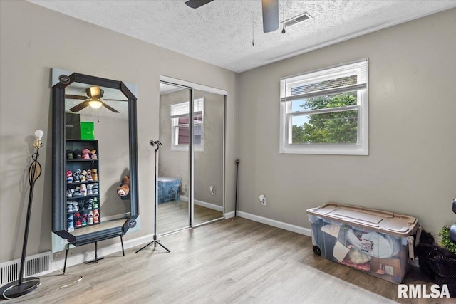 2900 Taylor Ave Unit 2, Springfield, IL 62703 - bedroom with wood finished floors, multiple windows, a textured ceiling, a closet, and a ceiling fan